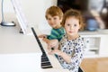 Two little kids girl and boy playing piano in living room or music school Royalty Free Stock Photo