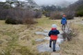 Two little kids hiking in the mountains of Palencia, Spain, during the winter ending and the spring beginning in a cold cloudy day