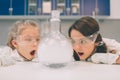 Two little kids in lab coat learning chemistry in school laboratory. Young scientists in protective glasses making Royalty Free Stock Photo