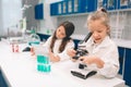 Two little kids in lab coat learning chemistry in school laboratory. Young scientists in protective glasses making Royalty Free Stock Photo