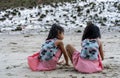 Two little kids making sand castle and playing at tropical beach. Little girls back view while playing sand on a beach Royalty Free Stock Photo