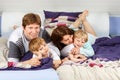 Two little kids and parents having fun in bed Royalty Free Stock Photo