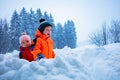 Two little kids play snowball in the snow fortress Royalty Free Stock Photo
