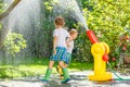 Two little kids playing with garden hose and water Royalty Free Stock Photo