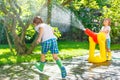 Two little kids playing with garden hose and water Royalty Free Stock Photo