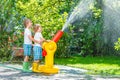 Two little kids playing with garden hose and water in summer Royalty Free Stock Photo