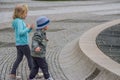 Two little kids playing next to a fountain