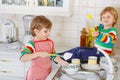 Two little lovely and funny kid boys washing dishes in domestic