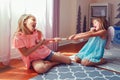 Two little mad angry girls sisters having fight at home. Friends girls can not share a toy. Lifestyle authentic funny family Royalty Free Stock Photo