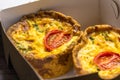 Two little mini tomato tartlets in take-away box close up - Savory mini quiches in a box Royalty Free Stock Photo