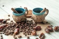 Two little old pottery handmade cups of coffee, coffee beans, sweet dried dates and cinnamon sticks