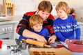Two little preschool boys and father baking gingerbread cookies. Happy siblings, children and their dad, man in xmas Royalty Free Stock Photo