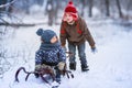 Two little preschool boys sledding in the snow Royalty Free Stock Photo