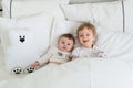 Two little pretty smiling brothers in bed, funny morning