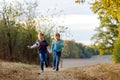 Two little school kids boys running and jumping in forest. Happy children, best friends and siblings having fun on warm Royalty Free Stock Photo