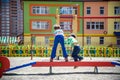 Two little school and preschool kids boys playing on playground outdoors together. children having competition standing on log Royalty Free Stock Photo