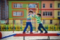 Two little school and preschool kids boys playing on playground outdoors together. children having competition standing on log Royalty Free Stock Photo