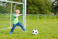 Two little sibling boys playing soccer and football on field Royalty Free Stock Photo