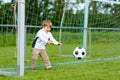 Two little sibling boys playing soccer and football on field Royalty Free Stock Photo