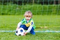 Two little sibling boys playing soccer and football on field Royalty Free Stock Photo