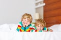 Two little sibling kid boys having fun in bed after sleeping Royalty Free Stock Photo