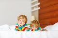 Two little sibling kid boys having fun in bed after sleeping Royalty Free Stock Photo