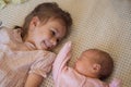 Two little siblings sisters together lying on blanket