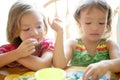 Two little sister girls eating together