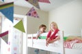 Two little sisters fooling around, playing and having fun in twin bunk bed Royalty Free Stock Photo