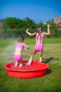 Two little sisters frolicing and splashing in Royalty Free Stock Photo