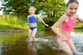 Two little sisters having fun on a sandy lake beach on warm and sunny summer day. Kids playing by the river Royalty Free Stock Photo