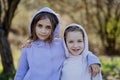 Two little sisters looking at camera in spring nature together. Royalty Free Stock Photo