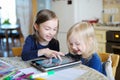 Two little sisters playing with a digital tablet Royalty Free Stock Photo