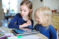 Two little sisters playing with a digital tablet Royalty Free Stock Photo