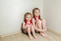 Two little sisters sit quietly on the floor in the nursery. Royalty Free Stock Photo
