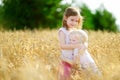 Two little sisters in wheat field on summer day Royalty Free Stock Photo