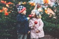 Two little smiling kids, boy and girl eating crystalized sugared apple on German Christmas market. Happy friends in Royalty Free Stock Photo