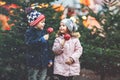 Two little smiling kids, boy and girl eating crystalized sugared apple on German Christmas market. Happy friends in Royalty Free Stock Photo