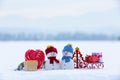 Two little snowman with the sledge, gift boxs, striped red white heart candy. Lawn covers with snow. Beautiful winter day. Royalty Free Stock Photo