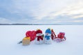 Two little snowman with the sledge, gift boxs, striped red white heart candy. Lawn covers with snow. Beautiful winter day. Royalty Free Stock Photo