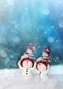 Two little snowmen in caps on snow in the winter. Background with a funny snowman. Christmas card Royalty Free Stock Photo