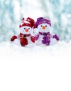 Two little snowmen the girl and the boy in caps and scarfs on snow in the winter. Background with a funny snowman Royalty Free Stock Photo