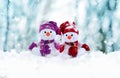 Two little snowmen the girl and the boy in caps and scarfs on snow in the winter. Background with a funny snowman. Christmas card Royalty Free Stock Photo