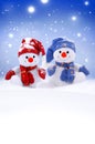 Two little snowmen the girl and the boy in caps and scarfs on snow in the winter. Background with a funny snowman. Christmas card Royalty Free Stock Photo