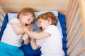 Two little toddler boys having fun and fighting