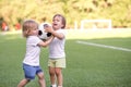 Two little toddler kids arguing at playground or stadium over soccer ball. Conflict management, hostile merger concept