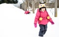Two little twin girls are playing in the snow. Dressed in winter