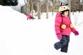 Two little twin girls are playing in the snow