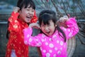 Two little Vietnamese girls play and laugh in national costumes