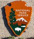 Two Lizards Hide Behind National Park Logo Sign Royalty Free Stock Photo